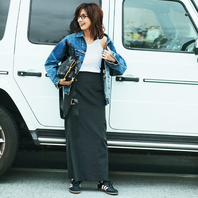 黒タイトスカートに白タンクトップとデニムジャケットを合わせた東原亜希さん