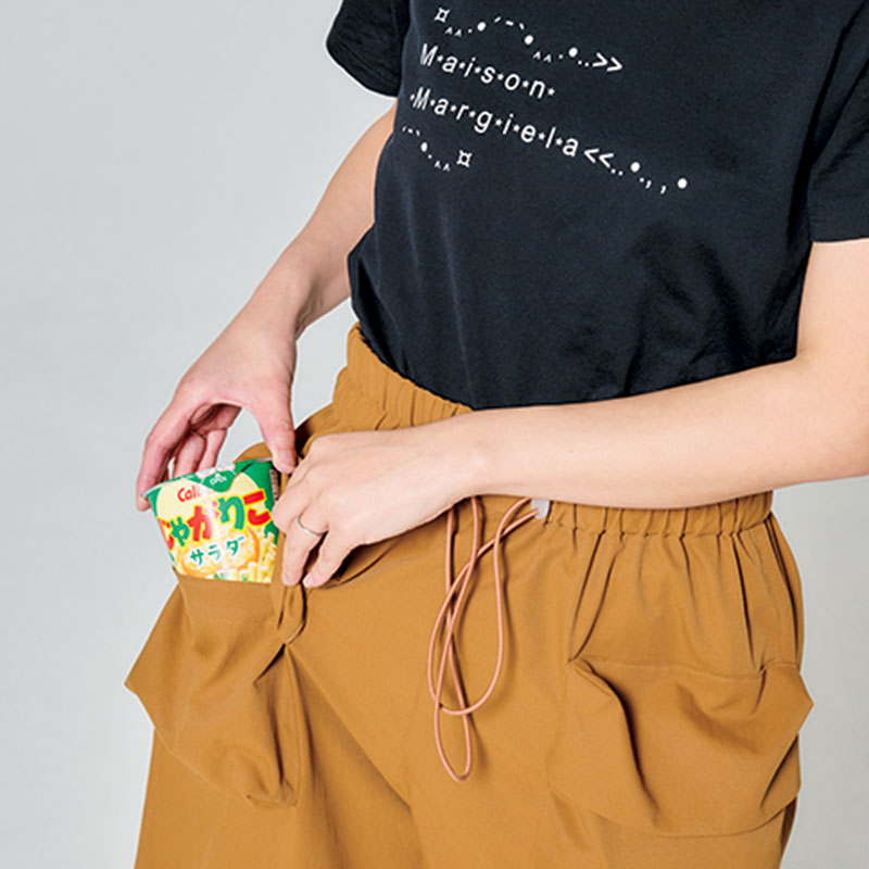 ショートパンツのポケットにお菓子を入れるライター