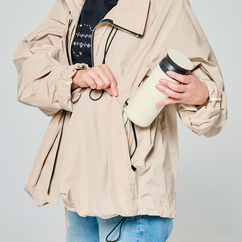 ブルゾンのポケットに水筒を入れるライター