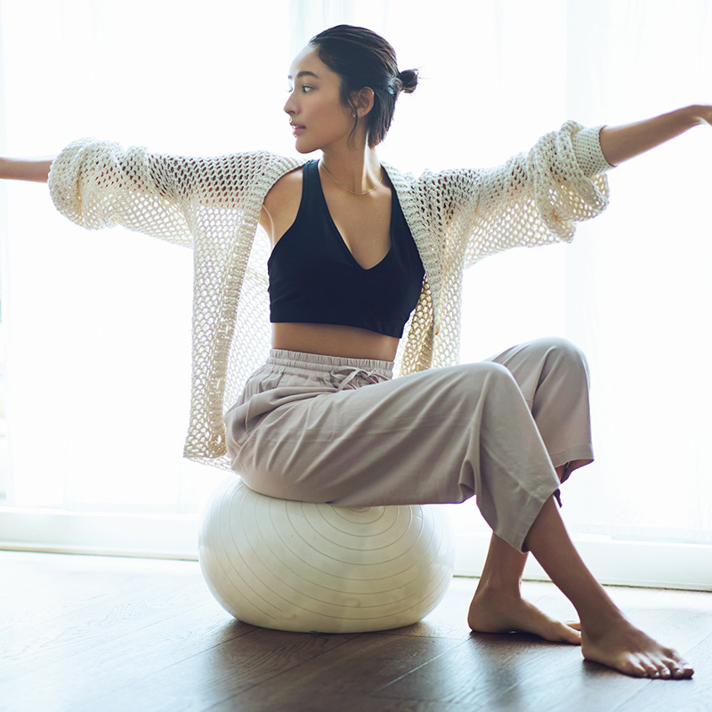 バランスボールの上に乗ってエクササイズをするモデルのイメージカット