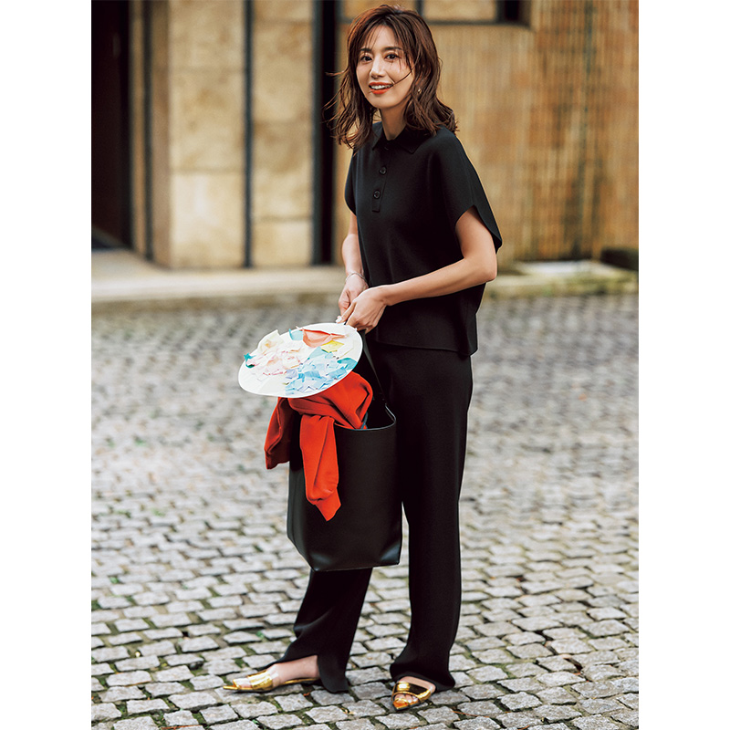 黒の半袖ポロニットとパンツのセットアップを着る東原亜希さん